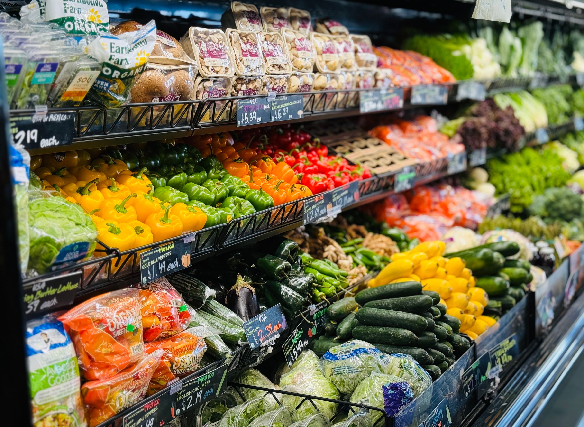 Rayon fruits et légumes d'un supermarché, étiquettes de prix visibles